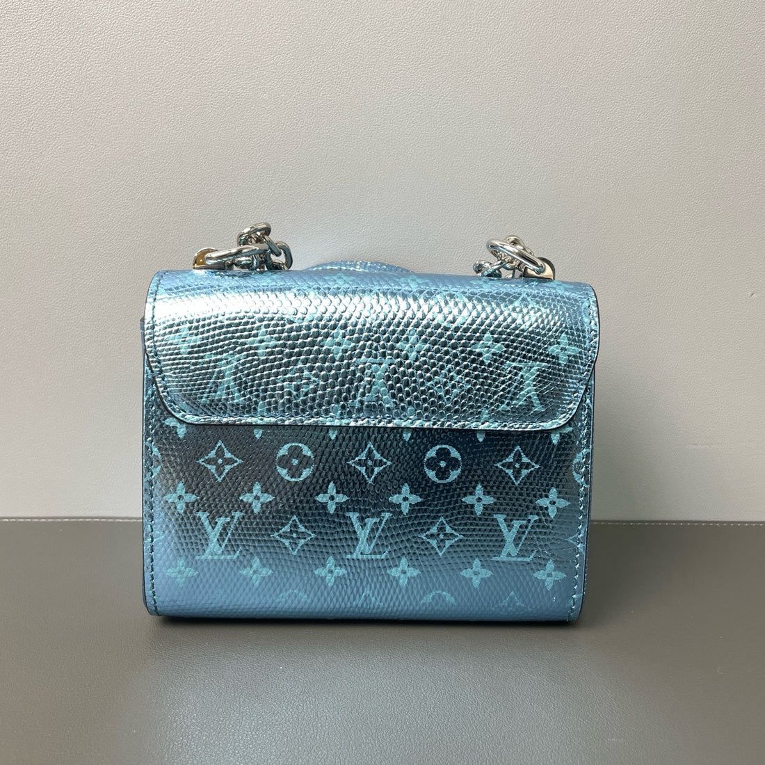 Louis Vuitton mini Twist handbag, made of lizard skin and decorated with a blue Monogram pattern.