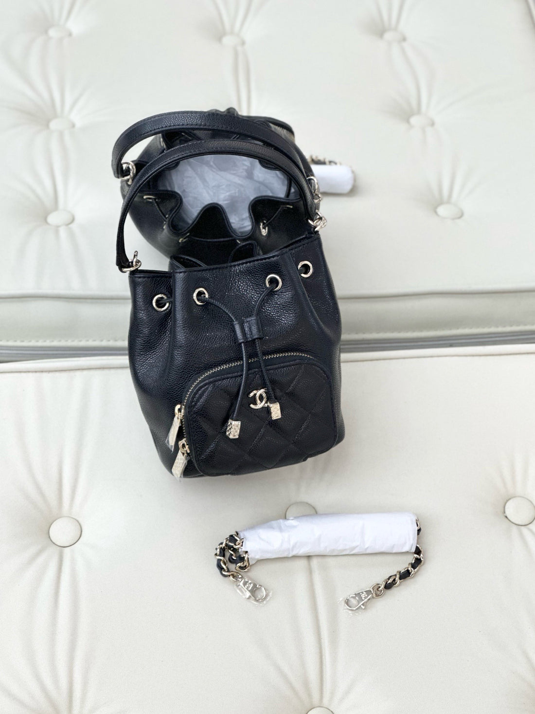 Chanel women's quilted shoulder bag in black caviar-textured leather.