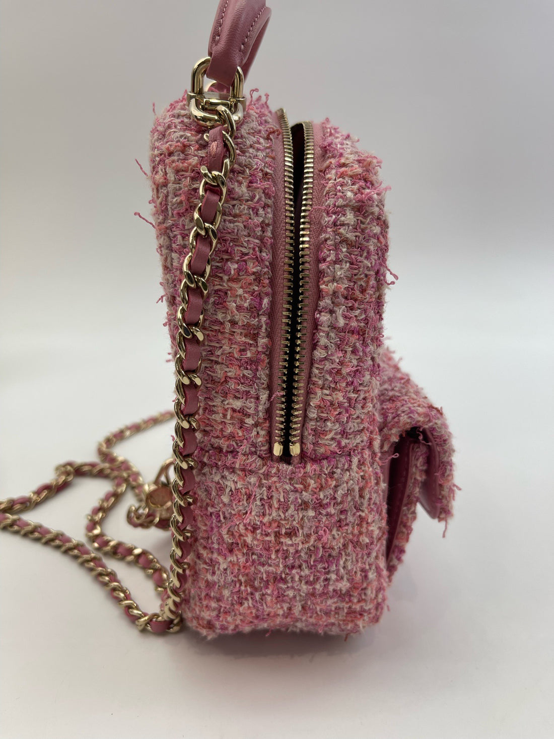 Chanel's classic mini backpack, made of pink tweed fabric, with gold-tone hardware.